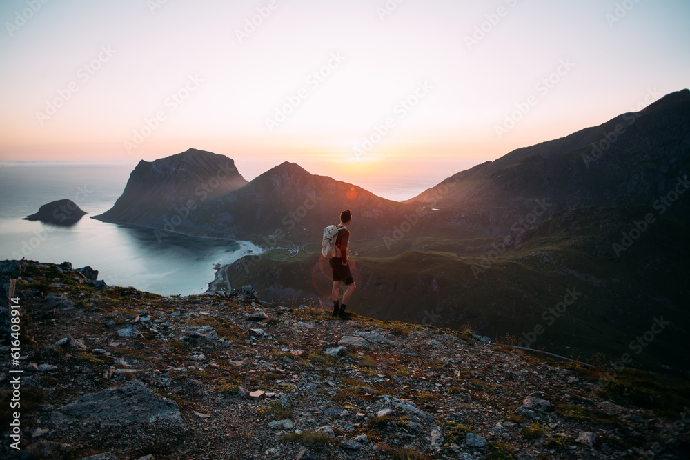 Young athletic man with backpack hike to reach summit of mountain at sunset. Cinematic beautiful adventure. Inspiring time spent outdoors. Explore norway in summer Young athletic man with backpack hike to reach summit of mountain at sunset. Cinematic beautiful adventure. Inspiring time spent outdoors. Explore norway in summer