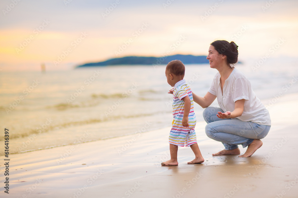 Mother and baby on tropical beach at sunset. Mother and baby on tropical beach at sunset.