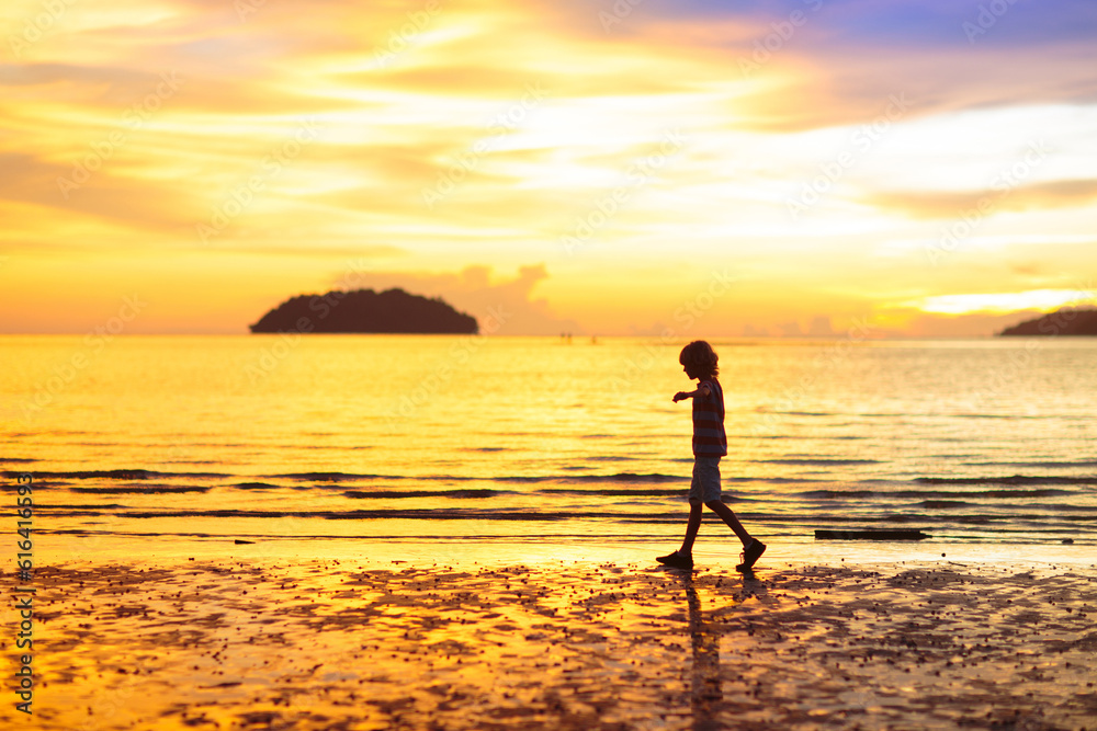 Child playing on ocean beach. Kid at sunset sea. Child playing on ocean beach. Kid at sunset sea.