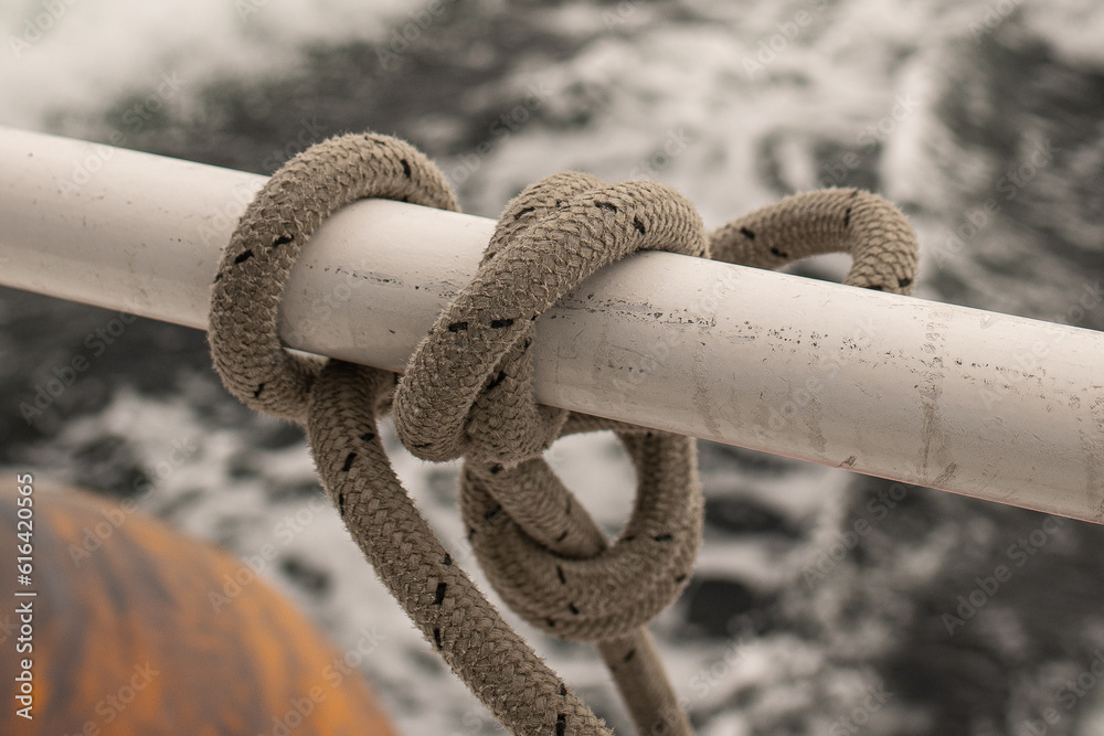 ship's mooring rope coiled and knotted to the railing of a cruise ship ...
