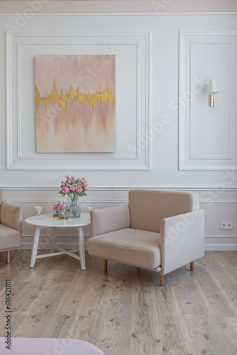 a close view of a tea table with two stylish armchairs in a modern cozy soft interior in warm delicate pastel pink and beige colors