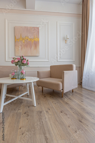 a close view of a tea table with two stylish armchairs in a modern cozy soft interior in warm delicate pastel pink and beige colors