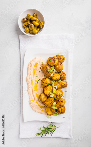 Whipped feta, ricotta, cheese dip (Tirokafteri) with crispy baked potatoes and grilled olives photo