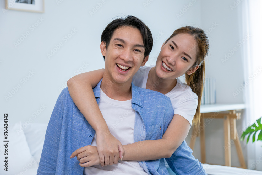 Young couple watching tv series laughing happily using tablet and sitting on sofa bed
Young couple watching tv series laughing happily using tablet and sitting on sofa bed