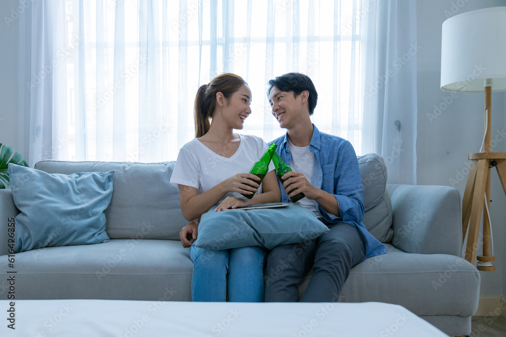 Young couple watching tv series laughing happily using tablet and sitting on sofa bed
Young couple watching tv series laughing happily using tablet and sitting on sofa bed