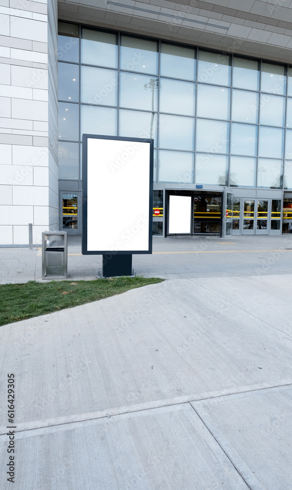 Fototapeta premium Empty vertical street billboard stand with mall background.