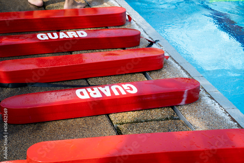 Selective focus shot of a red Plastic guards beside the swimming pool. Floating block for kids swimming training course use. 