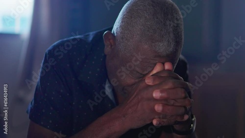 Close-up of Devout Black Senior Man in Prayer Seeking God's help. Elderly African American person on his knees with hands clenched