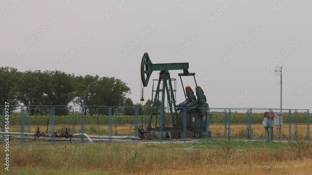 Pumping Oil Well Pump Jack at Agriculture Field Pumping Oil Well Pump Jack at Agriculture Field