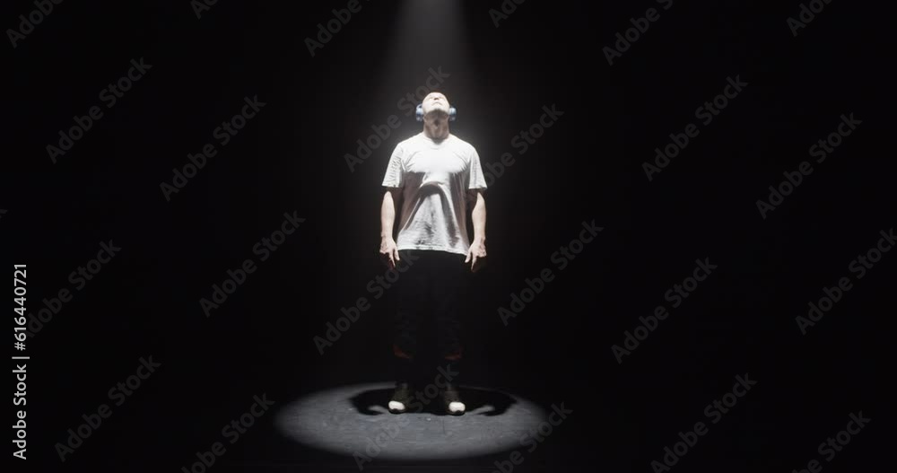 Male dancer coming out of darkness into spotlight Male dancer coming out of darkness into spotlight