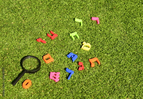 Multi-colored letters of the Israeli alphabet on green grass. Concept: ulpan for immigrant children, language learning, school in Israel photo