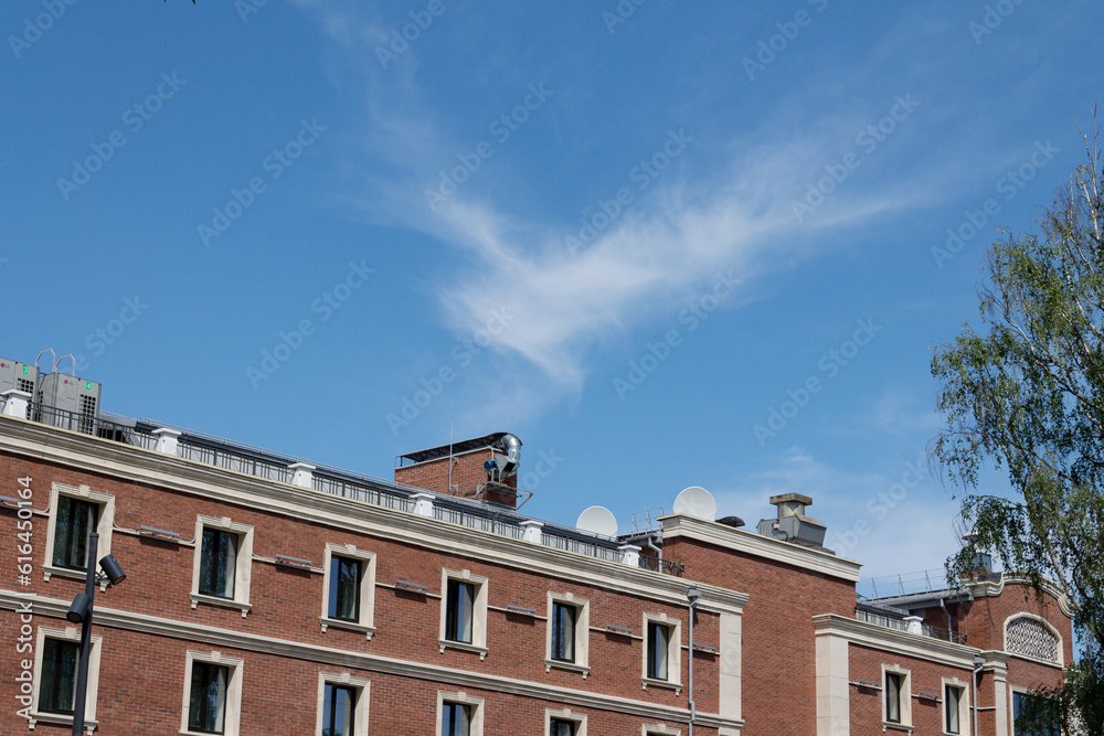 a cloud in the form of a flying angel in the blue sky above the building
