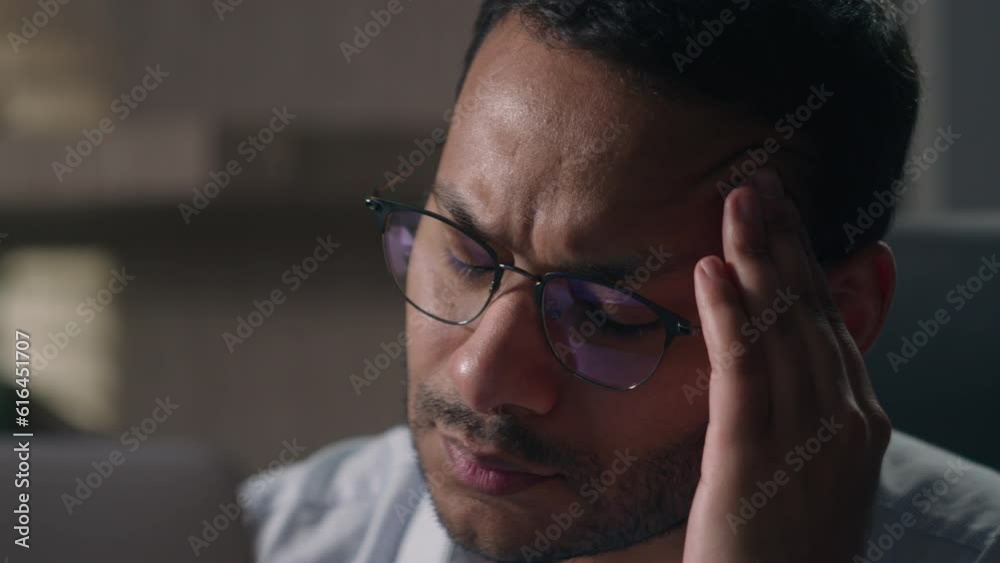 Tired busy Indian man in glasses Arabian businessman American employer suffering from head pain tension headache migraine rubbing temple thinking ponder business problem solution with computer laptop Tired busy Indian man in glasses Arabian businessman American employer suffering from head pain tension headache migraine rubbing temple thinking ponder business problem solution with computer laptop