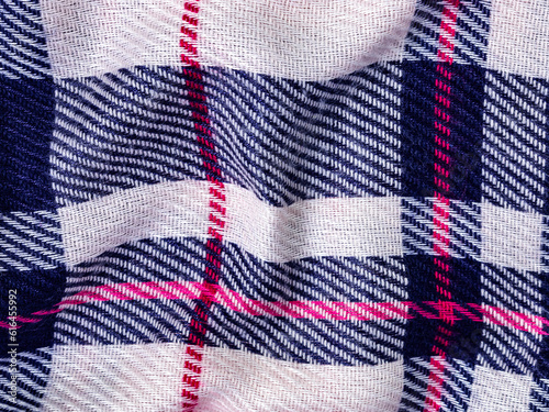 Texture of woolen scarf in Scottish ethnic style. Pink, blue and white stripes, shawl top view. Autumn background