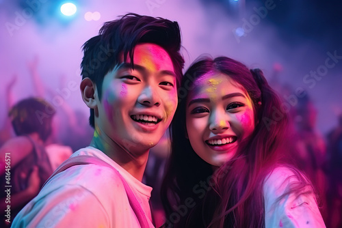 A young Asian couple smiles at a music festival , having super fun