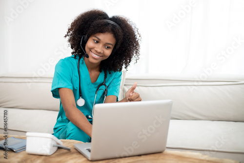 Shot of Africa American female doctor talking with colleagues through a video call with a laptop in the consultation. Home health care concept.