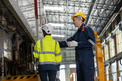 Two professional engineers checkmechanical check undercarriage of lifted electric train and maintenance of public transport trains in Asia