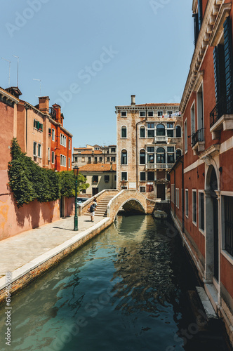 Tourist in summer under the sun posing and taking pictures on venice old bridges with venetian architecture and canals