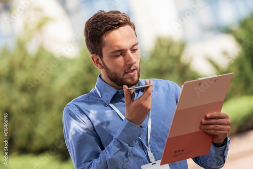 Businessman sending voice messages. He is using new technology photo