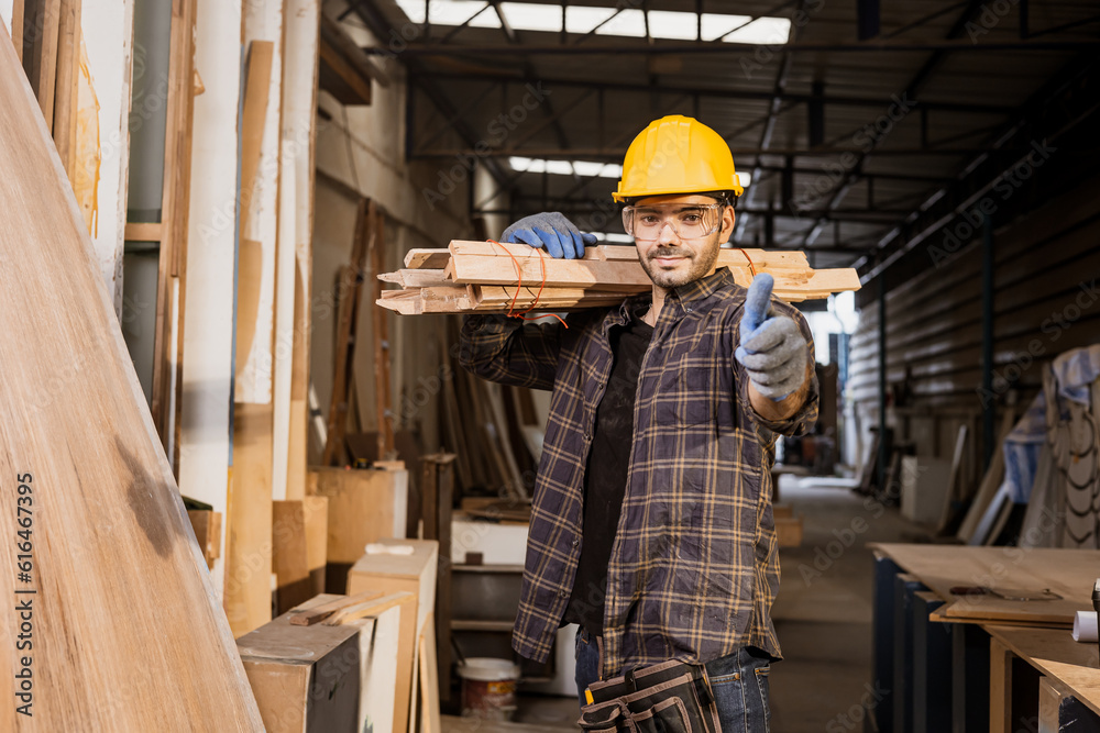Smart male construction worker work carry wooden pile in furniture factory standing thumbs up smiling.