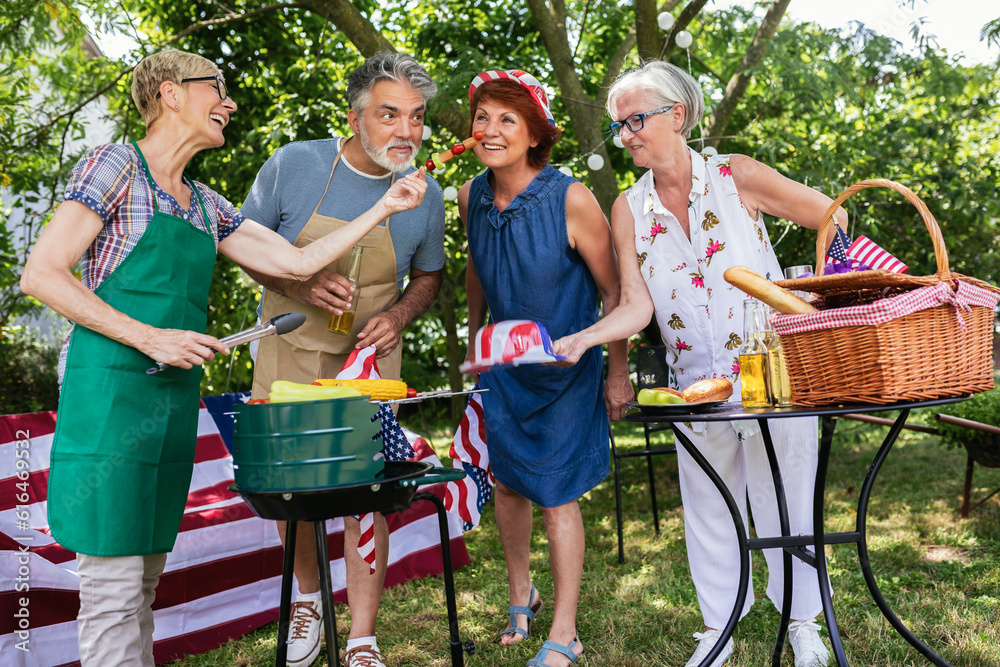 Obraz premium A group of elderly people celebrates the 4th of July in a backyard while making barbeque.