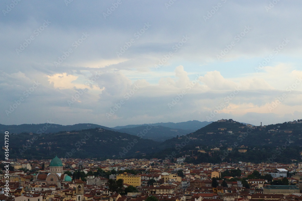 View from Piazzale Michelangelo of Florence city, cloudy sky, mountains in the background, city view from above, italy.