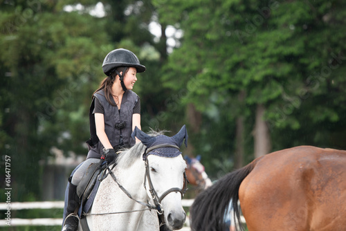 雨の日に乗馬の練習をする少女