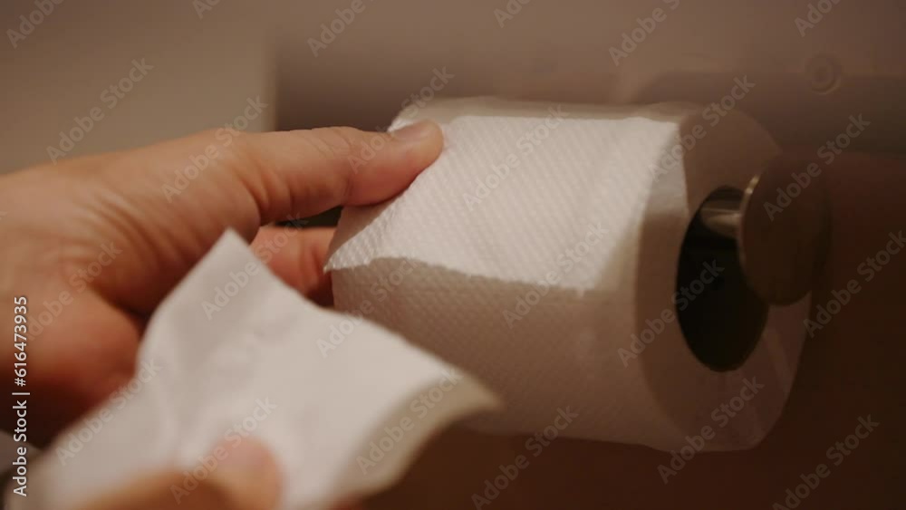 A person is using a roll of toilet paper. This close up video shows