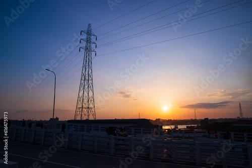 Silhouette of the high voltage power line at sunset in Narayanganj, Bangladesh photo