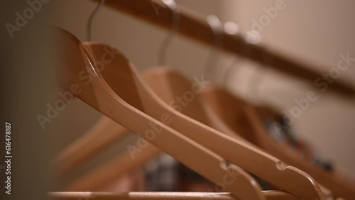 Empty wooden clothing hangers hanging on metal rack close up view. Shopping and discount concept.