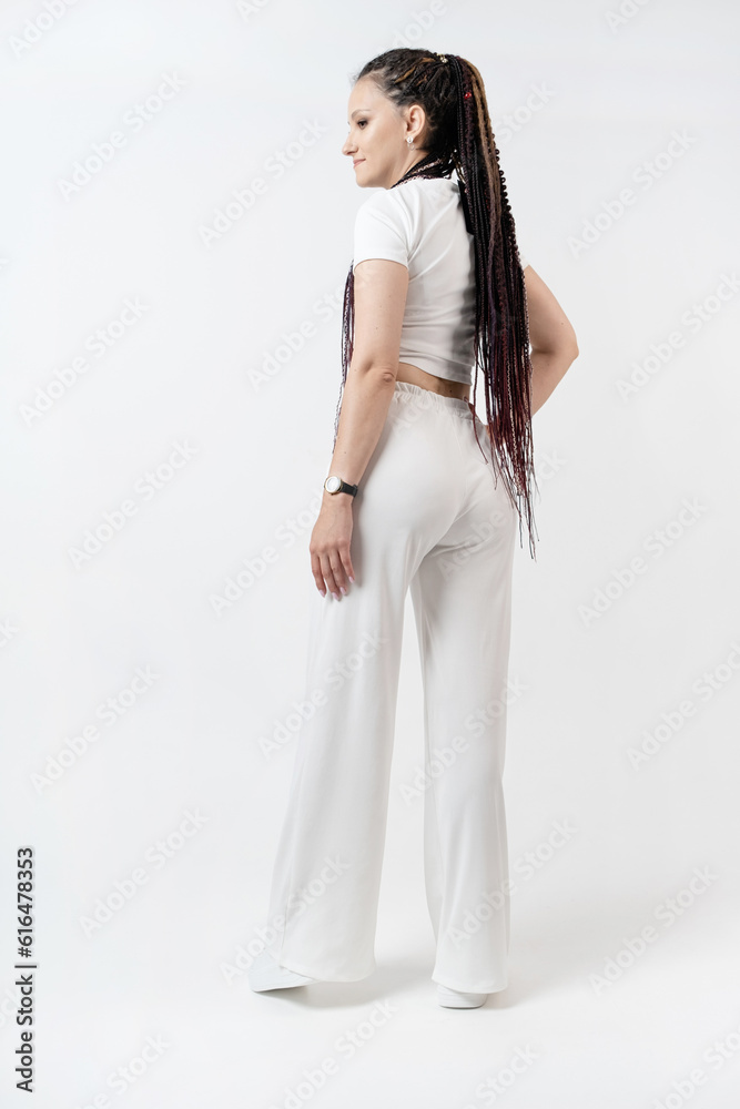Fashionable young beautiful woman with dreadlocks posing on white background Fashionable young beautiful woman with dreadlocks posing on white background