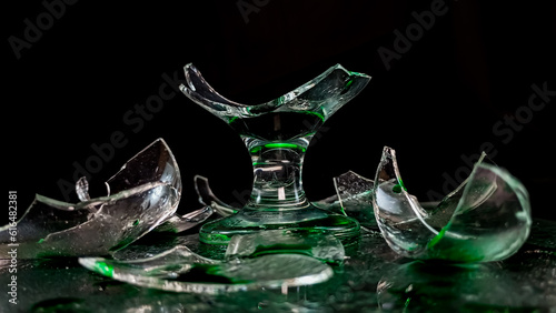 gelas pecah dengan cairan hijau berlatar gelap photo