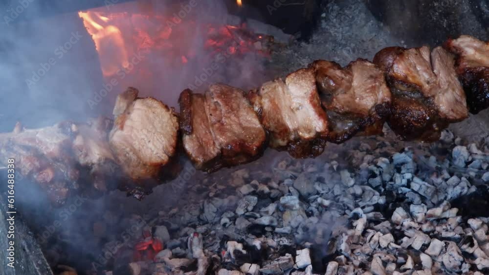 Shish kebab during grilling on the skewer on brazier, outdoors Shish kebab during grilling on the skewer on brazier, outdoors