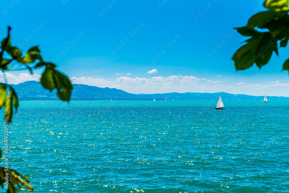 Germany, bodensee lake constance panorama view on sunny day, many sailboats enjoy the paradise like nature landscape and water sports