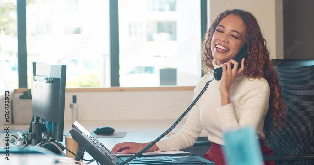 Medium shot of young woman answering phone at front desk, smiling and laughing Medium shot of young woman answering phone at front desk, smiling and laughing