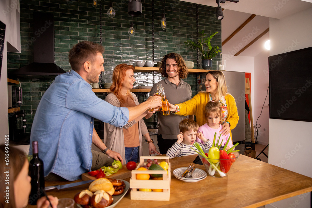 Two families toasting with cider while preparing dinner in the kitchen Two families toasting with cider while preparing dinner in the kitchen