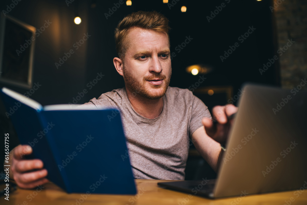 Concentrated man with notebook studying on laptop Concentrated man with notebook studying on laptop