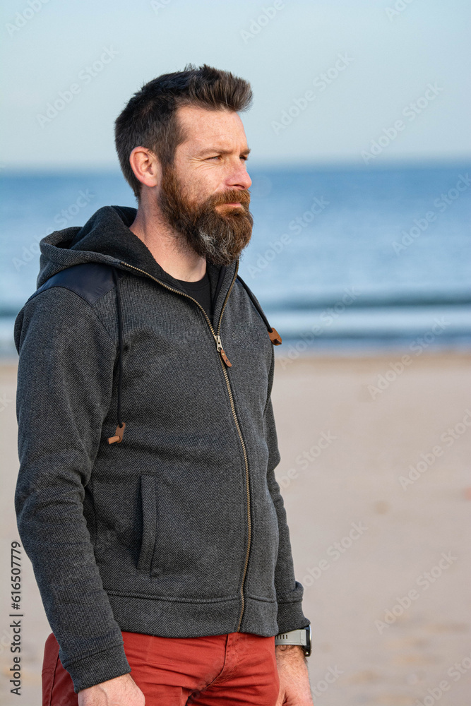 Portrait of man standing on sandy beach. bearded man at beach Portrait of man standing on sandy beach. bearded man at beach