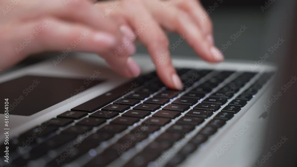 Female fingers press laptop keyboard