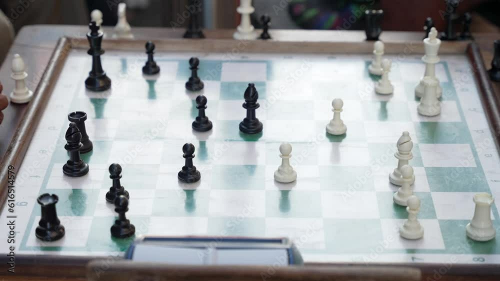 The hands of elderly men fast playing chess on the street outside The hands of elderly men fast playing chess on the street outside