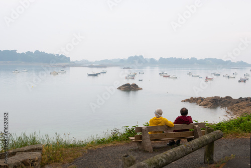 Un couple assis sur un banc face à la mer - Port-Blanc Penvénan en Bretagne