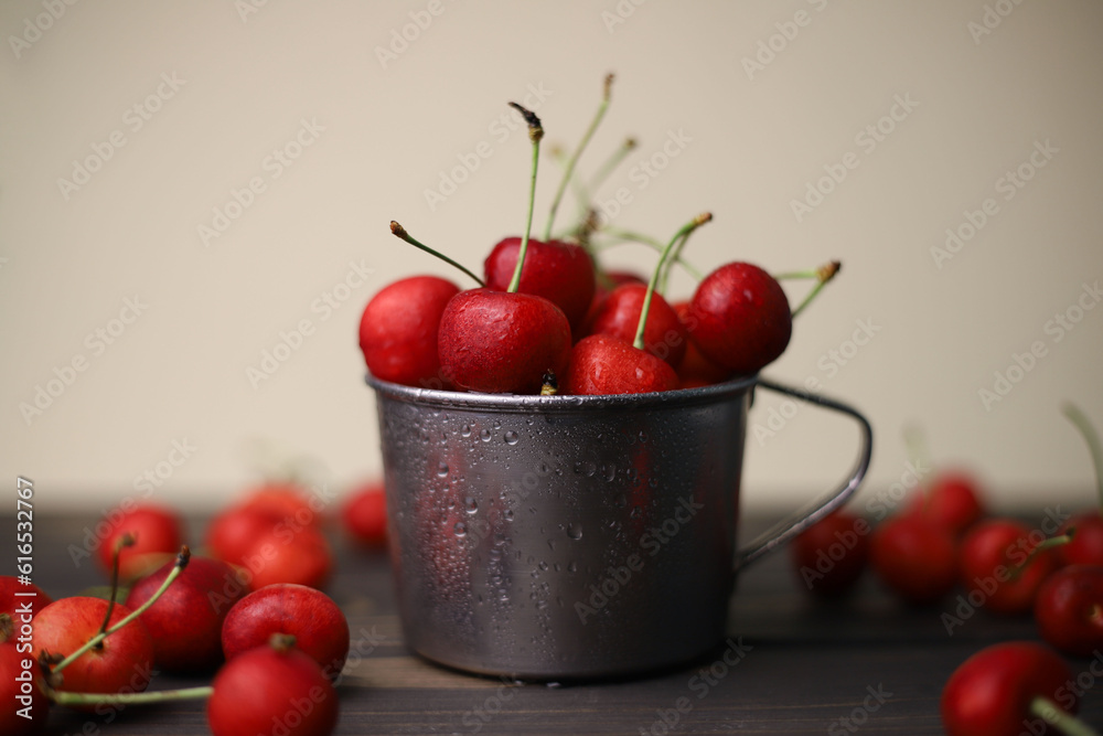 ripe summer sweet red cherry with water drops in a tin cup on a wooden and light background. for leaflets screensavers postcards advertising and more ripe summer sweet red cherry with water drops in a tin cup on a wooden and light background. for leaflets screensavers postcards advertising and more