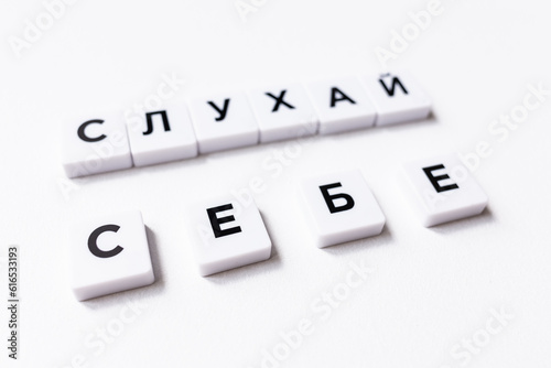 In harmony with yourself. Listen to yourself. Motivational inscription in Ukrainian. A call to listen to yourself. A word from the letters of the Scrabble game. Be kind to yourself. Trust yourself.