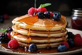 A stack of pancakes with syrup and berries on a plate