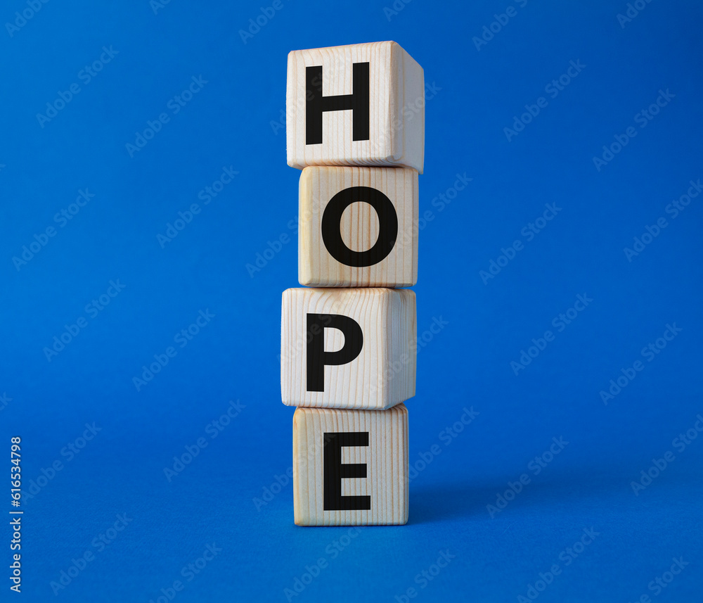 Hope symbol. Concept word Hope on wooden cubes. Beautiful blue background. Business and Hope concept. Copy space.