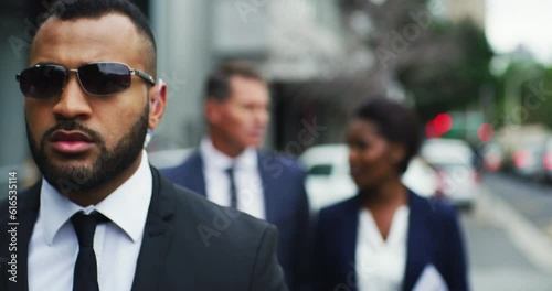 Serious African security guard and business people outdoor with protection for urban career. Bodyguard, walking and escort on street with sunglasses to protect professional in city with executives.