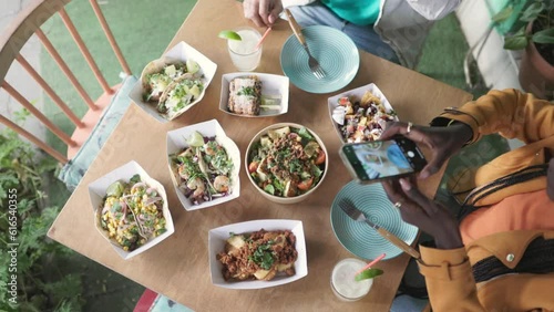 Woman taking food photos at restaurant on holidays, top view