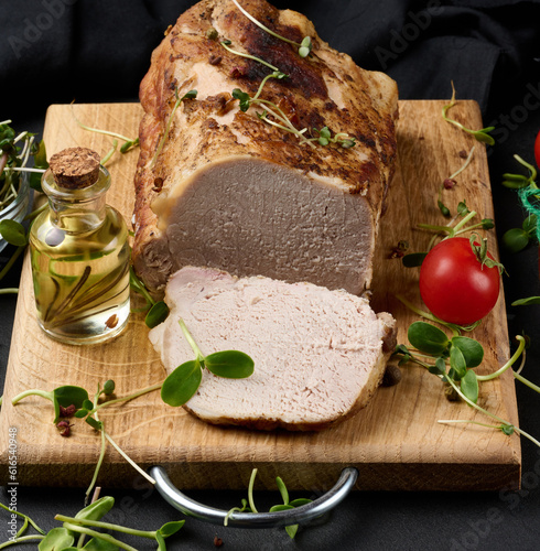 Baked piece of pork balyk on the table with spices. Tenderloin cut into pieces photo