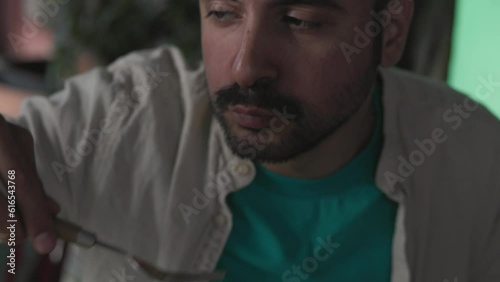 Man burning mouth eating spicy food and drinking cocktail, close-up