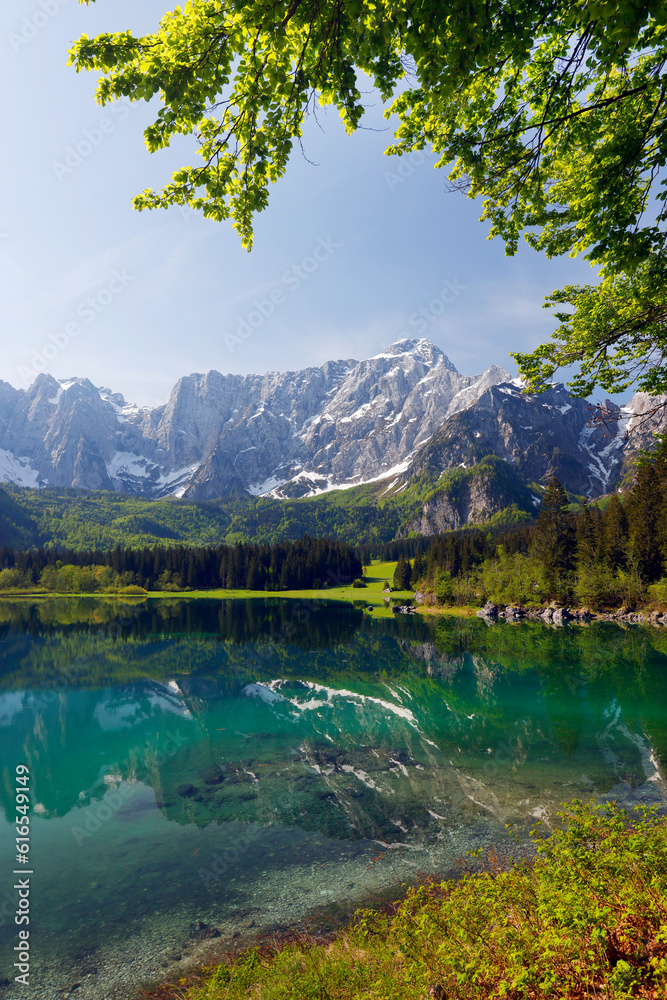 Obraz premium Picturesque mountain scenery and hiking place. Beautiful superior Fusine lake and Mangart mountain in background, Julian Alps, Tarvisio, Udine region, Friuli Venezia Giulia, Italy, Europe 